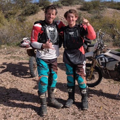 Father and son in full riding gear giving thumbs up